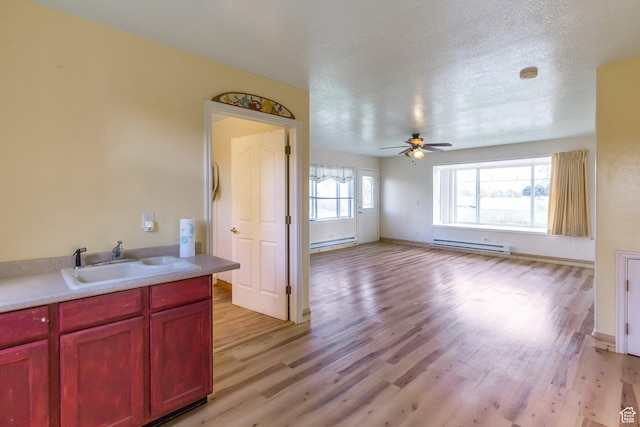 175 W 9200 S, Paradise, UT 84328 - kitchen featuring a sink, reddish brown cabinets, light wood-style flooring, a ceiling fan, and a baseboard radiator