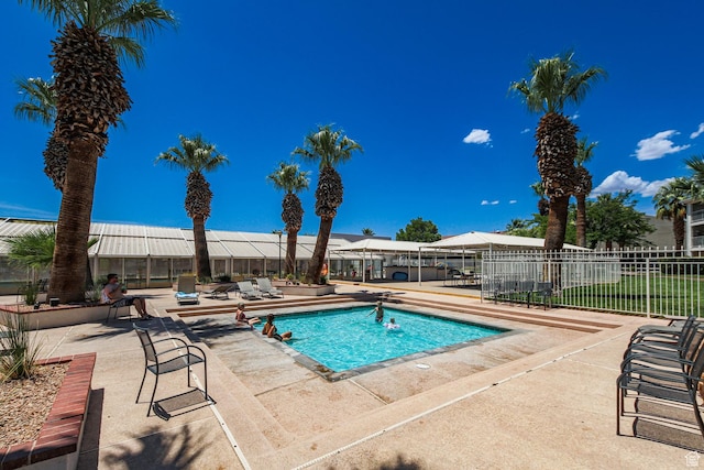 view of swimming pool with a patio and fence