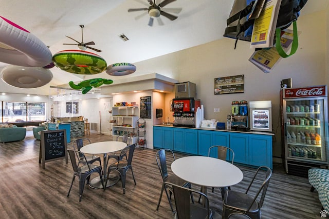 dining space featuring a community bar, a ceiling fan, visible vents, and wood finished floors