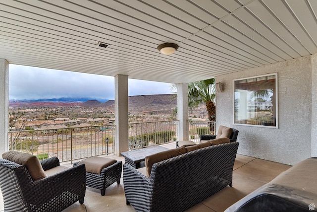 view of patio / terrace with a balcony and a mountain view