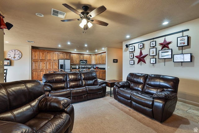 living area with a textured ceiling, recessed lighting, a ceiling fan, baseboards, and visible vents