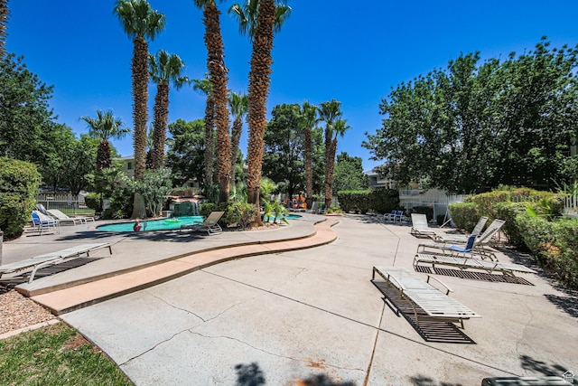 community pool with a patio and fence