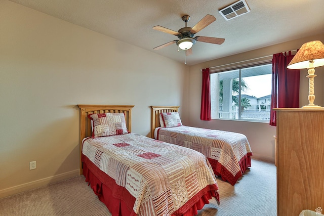 carpeted bedroom featuring visible vents, ceiling fan, a textured ceiling, and baseboards