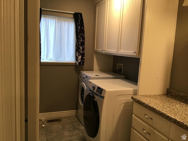 laundry area featuring visible vents, washer and clothes dryer, cabinet space, and baseboards