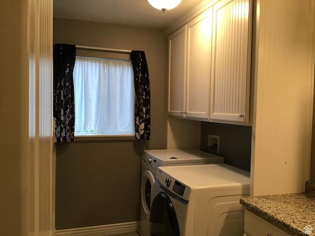clothes washing area featuring cabinet space and washing machine and clothes dryer