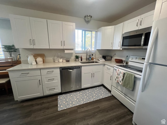 kitchen with dark wood-style floors, light countertops, appliances with stainless steel finishes, white cabinetry, and a sink
