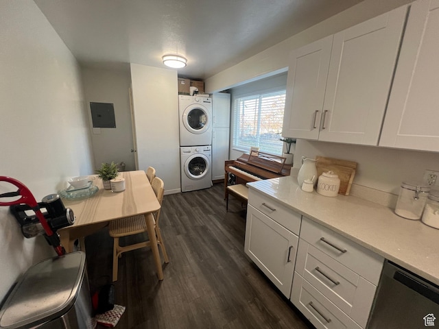 kitchen with dark wood-style flooring, light countertops, white cabinets, stacked washing maching and dryer, and electric panel