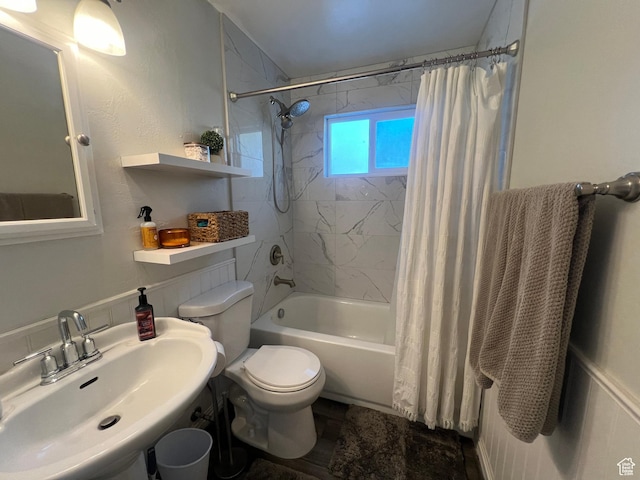 bathroom with toilet, shower / tub combo, and a sink