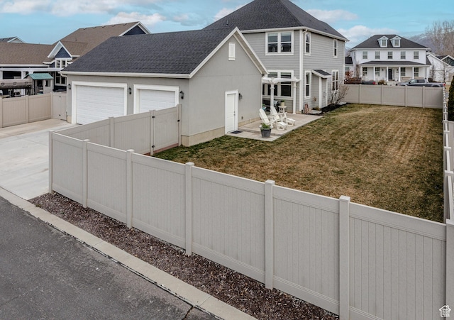 417 N Hill Farms Ln, Kaysville, UT 84037 - exterior space featuring a patio, a shingled roof, concrete driveway, a lawn, and a fenced backyard