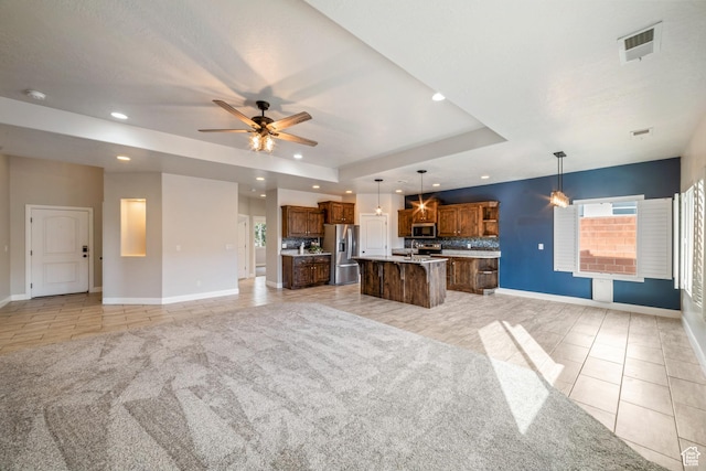 kitchen with stainless steel appliances, a raised ceiling, visible vents, open floor plan, and light tile patterned flooring