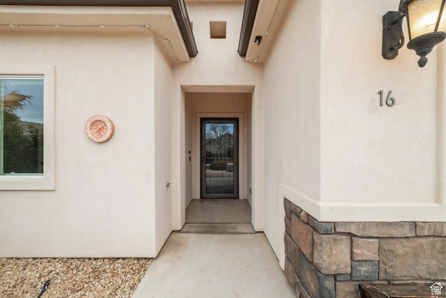 view of exterior entry with stucco siding