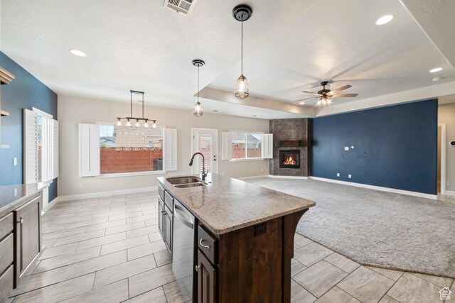 kitchen featuring baseboards, dishwasher, light colored carpet, a fireplace, and a sink