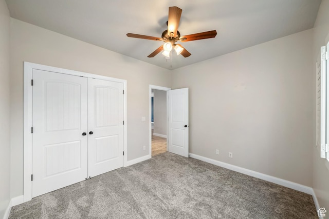 unfurnished bedroom featuring carpet, baseboards, ceiling fan, and a closet