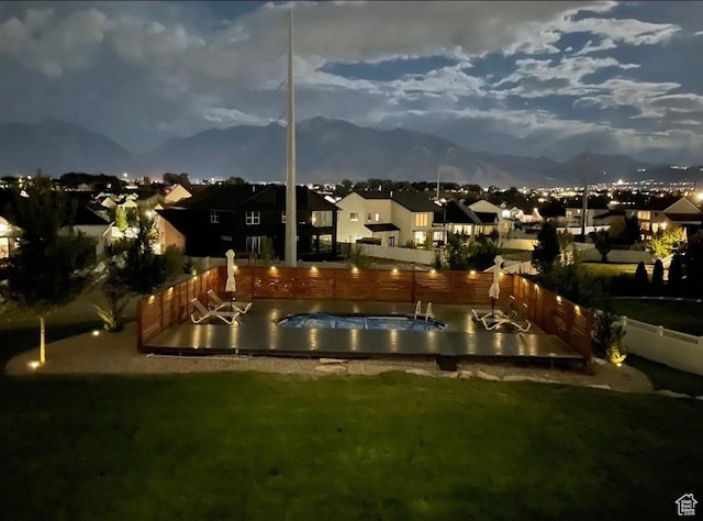 view of property's community featuring a swimming pool, a fenced backyard, a lawn, a mountain view, and a residential view
