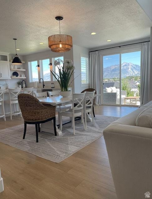dining room featuring recessed lighting, light wood-style flooring, and a textured ceiling