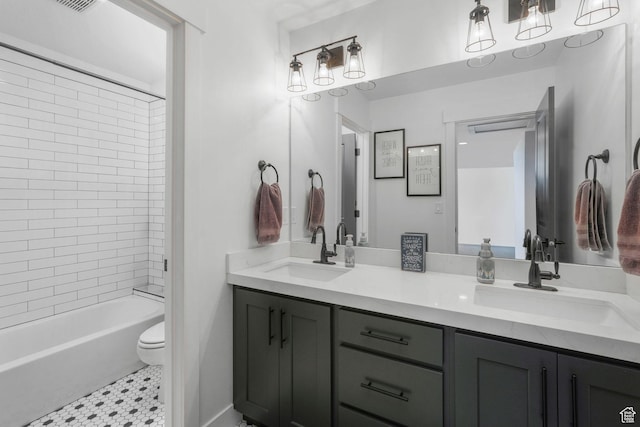 full bathroom featuring toilet, shower / tub combination, double vanity, and a sink
