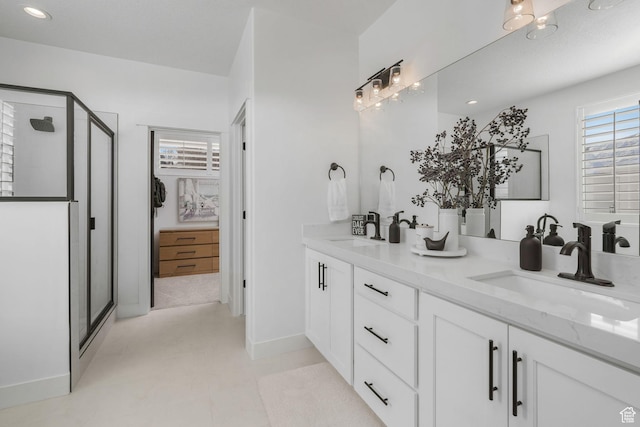 bathroom featuring a sink, a shower stall, and double vanity