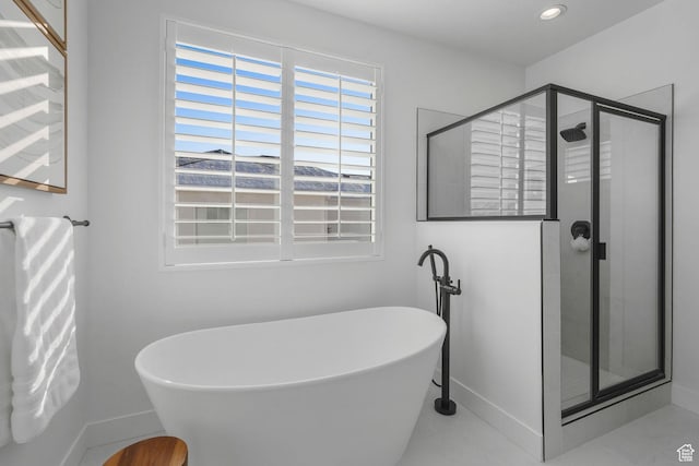 bathroom featuring a shower stall, a freestanding tub, baseboards, and recessed lighting