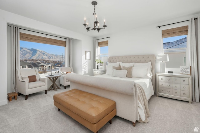 bedroom with light carpet, a mountain view, and an inviting chandelier