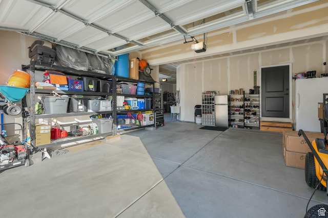 garage featuring a garage door opener and freestanding refrigerator