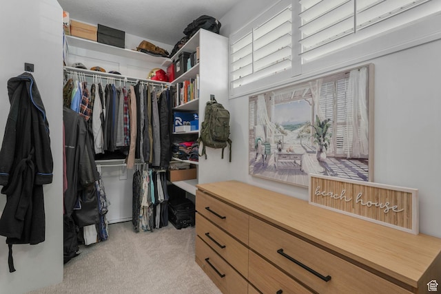 walk in closet featuring light carpet