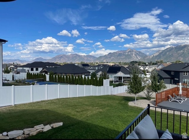view of yard with a mountain view, a fenced backyard, and a residential view
