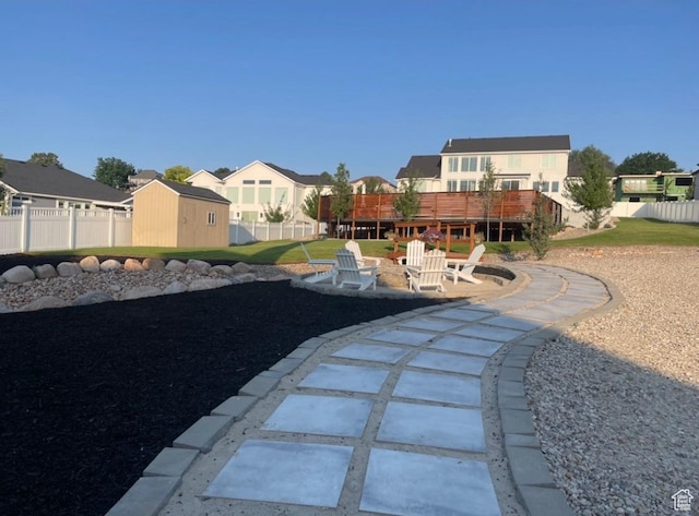 view of yard with a residential view, a patio, a storage shed, an outbuilding, and fence