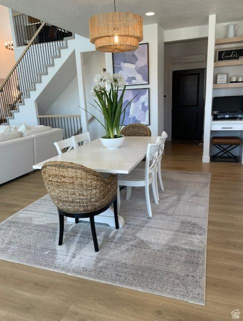 dining area with wood finished floors and stairs