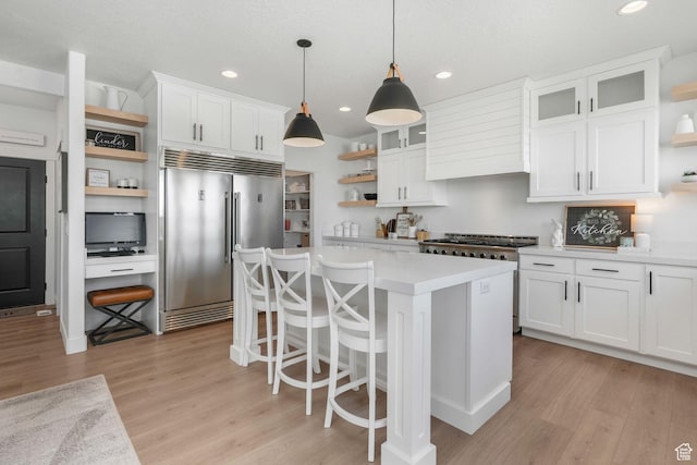 kitchen featuring white cabinets, open shelves, light countertops, stainless steel built in refrigerator, and light wood-style flooring