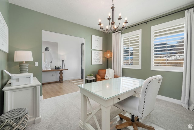 dining room with baseboards, a chandelier, and light carpet