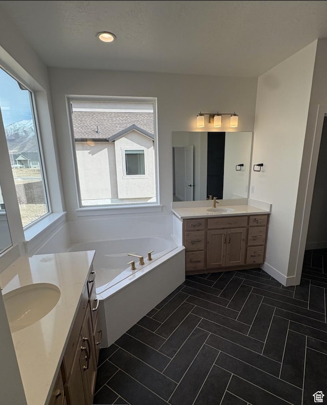 2387 E Canyon Crest Dr Unit 44, Spanish Fork, UT 84660 - full bathroom featuring baseboards, two vanities, tile patterned floors, a sink, and a bath