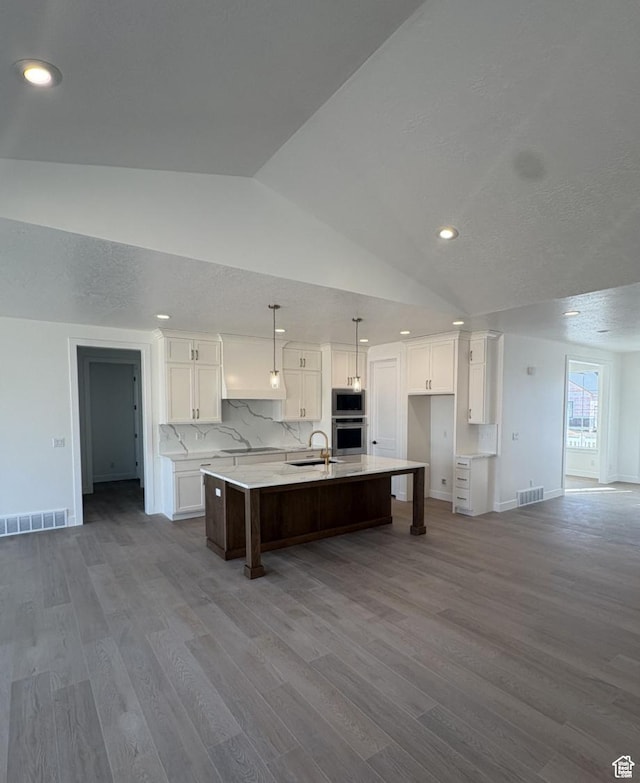 2387 E Canyon Crest Dr Unit 44, Spanish Fork, UT 84660 - kitchen featuring a large island, visible vents, stainless steel microwave, white cabinetry, and a sink