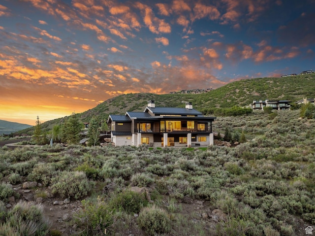 2344 Nighthawk Cir, Park City, UT 84098 - back of property with metal roof, a mountain view, roof mounted solar panels, a standing seam roof, and a chimney