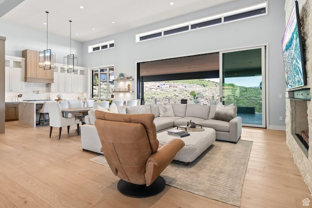 2344 Nighthawk Cir, Park City, UT 84098 - living area with an inviting chandelier, a high ceiling, light wood-type flooring, a fireplace, and recessed lighting