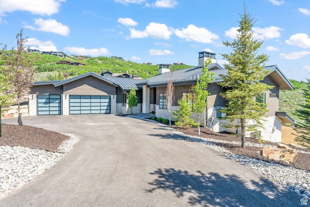 2344 Nighthawk Cir, Park City, UT 84098 - view of front of property with a chimney, concrete driveway, a standing seam roof, metal roof, and a garage