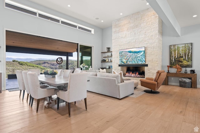 2344 Nighthawk Cir, Park City, UT 84098 - dining space featuring a fireplace, recessed lighting, light wood-style flooring, a high ceiling, and a mountain view