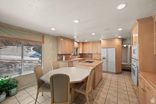 3604 S Crestwood Dr, Salt Lake City, UT 84109 - kitchen with a center island, white appliances, light countertops, and light brown cabinets