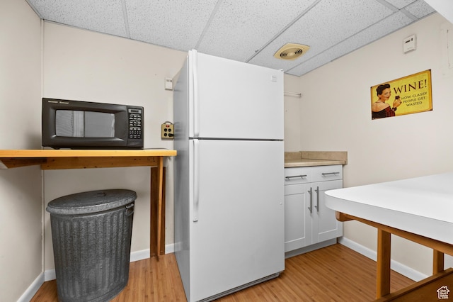 3604 S Crestwood Dr, Salt Lake City, UT 84109 - kitchen with light wood-style floors, freestanding refrigerator, black microwave, and a drop ceiling