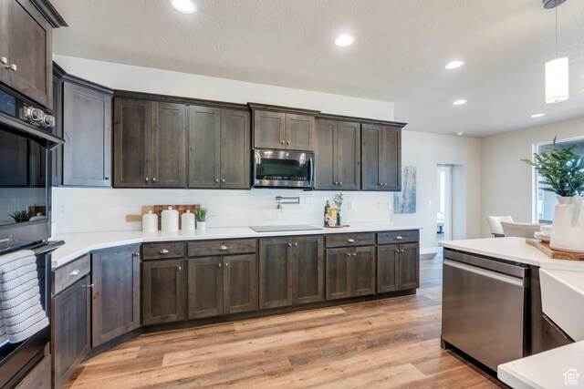 1407 E Abigail Ln, Eagle Mountain, UT 84005 - kitchen featuring stainless steel appliances, dark brown cabinets, backsplash, and light wood-style floors
