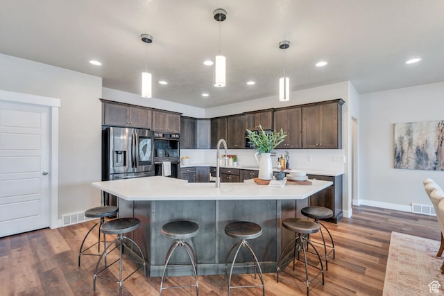 1407 E Abigail Ln, Eagle Mountain, UT 84005 - kitchen with dark brown cabinets, light countertops, visible vents, and stainless steel appliances