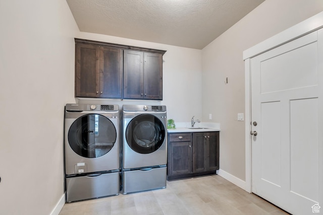 1407 E Abigail Ln, Eagle Mountain, UT 84005 - laundry area with washing machine and clothes dryer, cabinet space, a sink, a textured ceiling, and baseboards