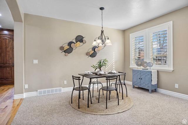 dining room featuring an inviting chandelier, baseboards, and visible vents