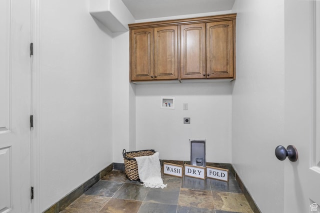 washroom with hookup for a washing machine, cabinet space, stone finish flooring, electric dryer hookup, and baseboards