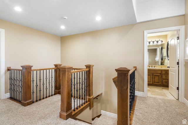 hallway featuring baseboards, recessed lighting, an upstairs landing, and light colored carpet