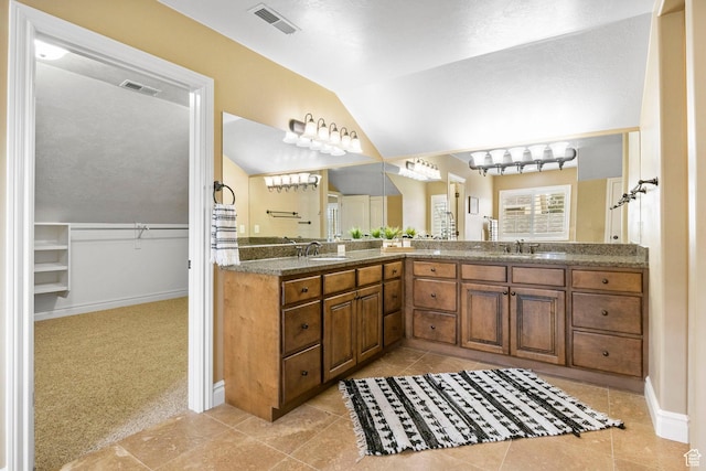 full bathroom with lofted ceiling, a spacious closet, visible vents, and a sink