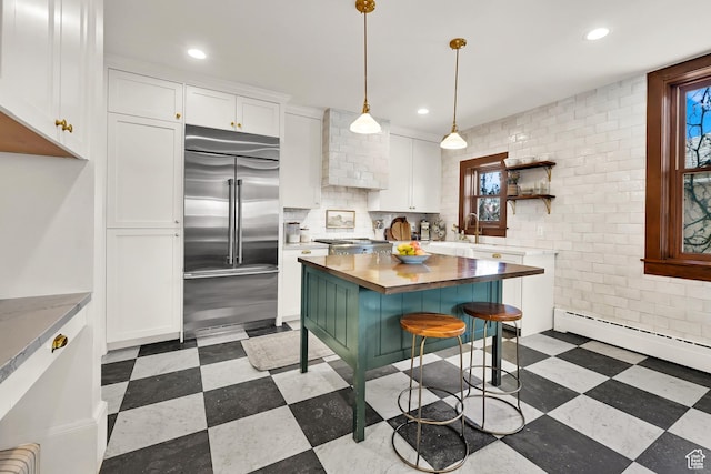 kitchen featuring recessed lighting, open shelves, stainless steel built in refrigerator, white cabinets, and butcher block counters