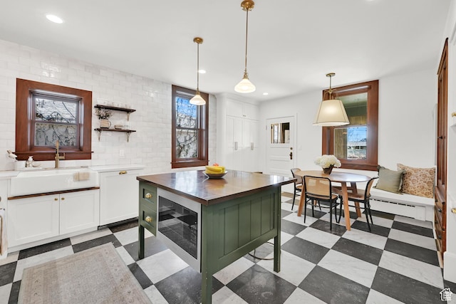 kitchen with recessed lighting, white cabinetry, a sink, and hanging light fixtures