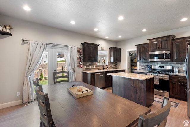 1933 E Handcart Ln N, Spanish Fork, UT 84660 - kitchen with appliances with stainless steel finishes, a sink, light wood-style flooring, and dark brown cabinets