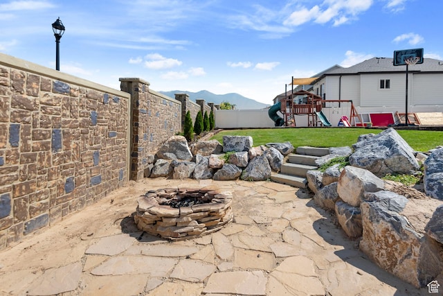 1933 E Handcart Ln N, Spanish Fork, UT 84660 - view of patio with an outdoor fire pit, a playground, a fenced backyard, and a mountain view