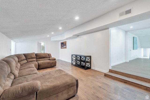 living room with recessed lighting, visible vents, a textured ceiling, and wood finished floors